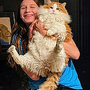 Hobbes joined the competition — help win amazing prizes! cat, person, orange_cat, white_cat, fluffy, long_hair, pet, animal, portrait, smiling, indoors, blue_shirt, black_pants, holding, arms, whiskers, ears, tail, fur, happy