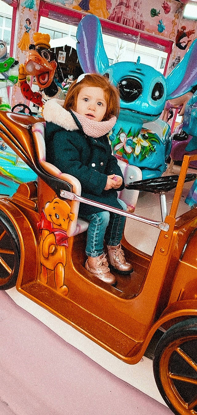 Margot a rejoint le concours — aidez-le/la à gagner de superbes lots ! child, event, fictional_character, fun, happy, hat, leisure, mammal, motor_vehicle, people, person, public_space, recreation, sitting, smile, snapshot, tire, toddler, toy, vertebrate
