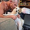 Hammy joined the competition — help win amazing prizes! man, dog, couch, indoor, shirtless, pet, affection, furniture, shelf, clutter, computer, monitor, electronics, casual, relaxation, portrait, home, human, animal, love