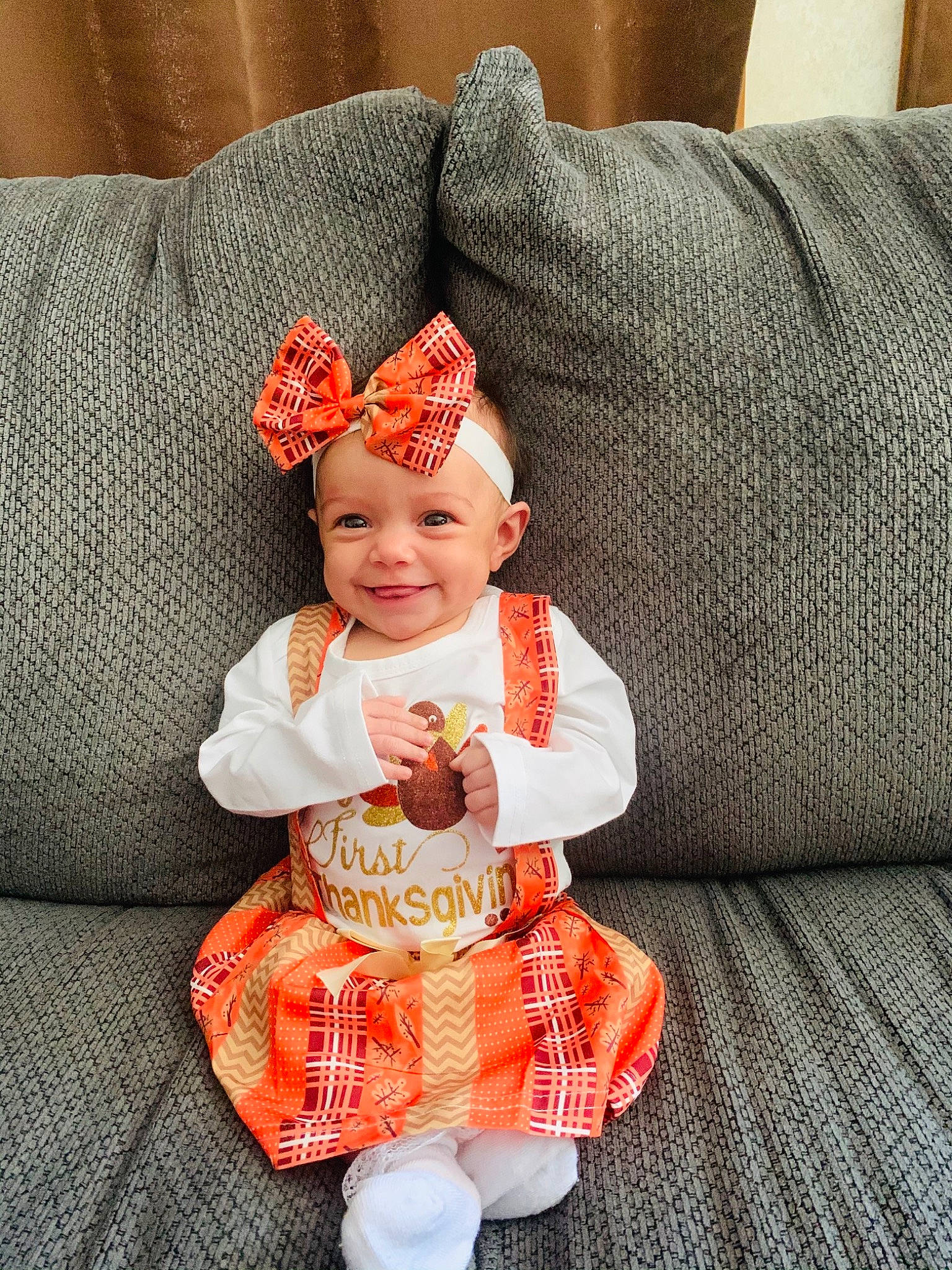 Emberleigh is registered to the contest to win money with this photo: baby, baby_products, baby_toddler_clothing, bonnet, child, comfort, costume, costume_accessory, couch, headgear, headwear, human, human_body, joy, mouth, nose, orange, peach, person, sock