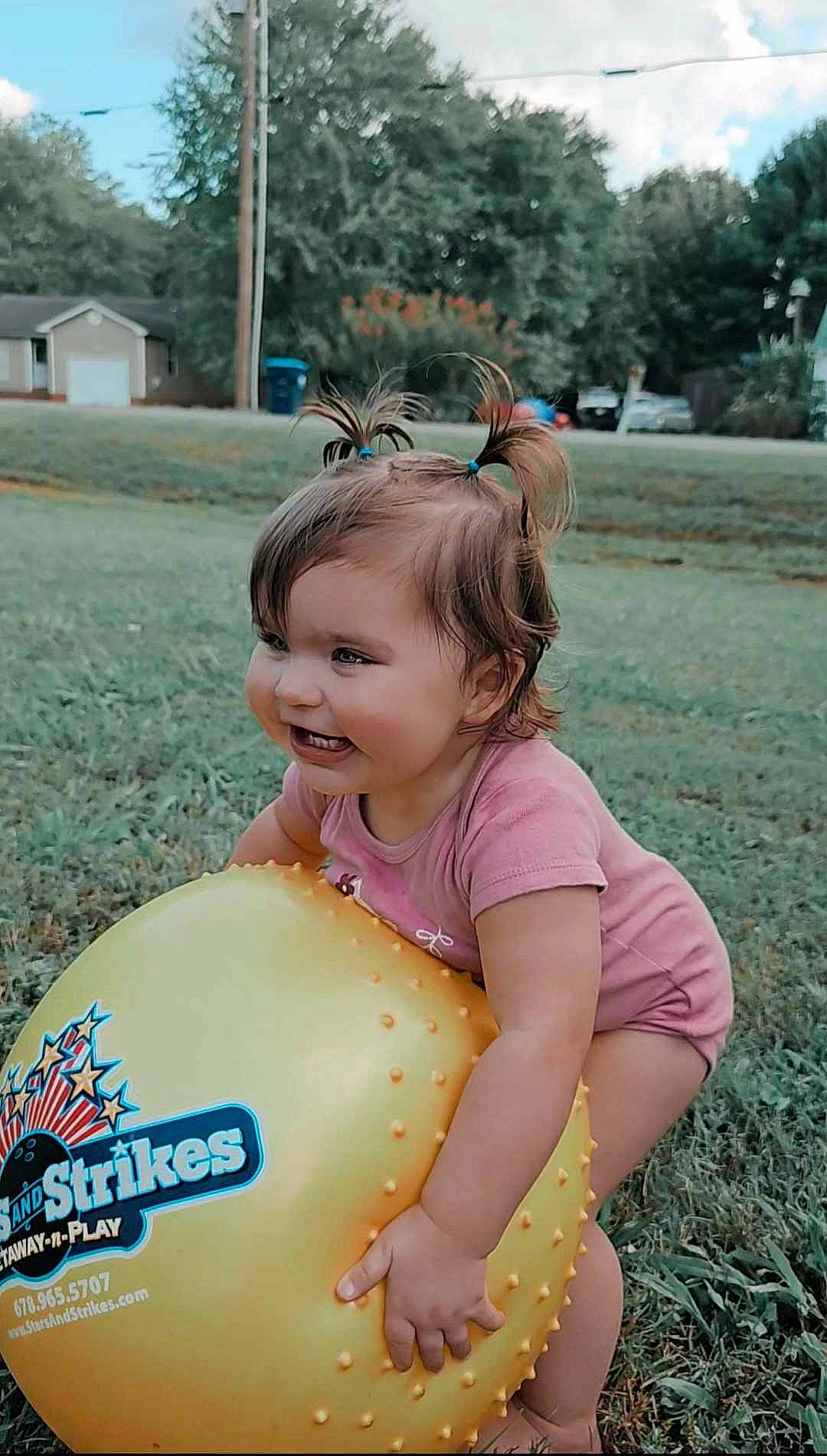 Iris is registered to the contest to win money with this photo: child, eye, fashion_accessory, fun, grass, happy, leisure, magenta, people_in_nature, person, personal_protective_equipment, pink, plant, recreation, skin, sky, smile, summer, toddler, tree