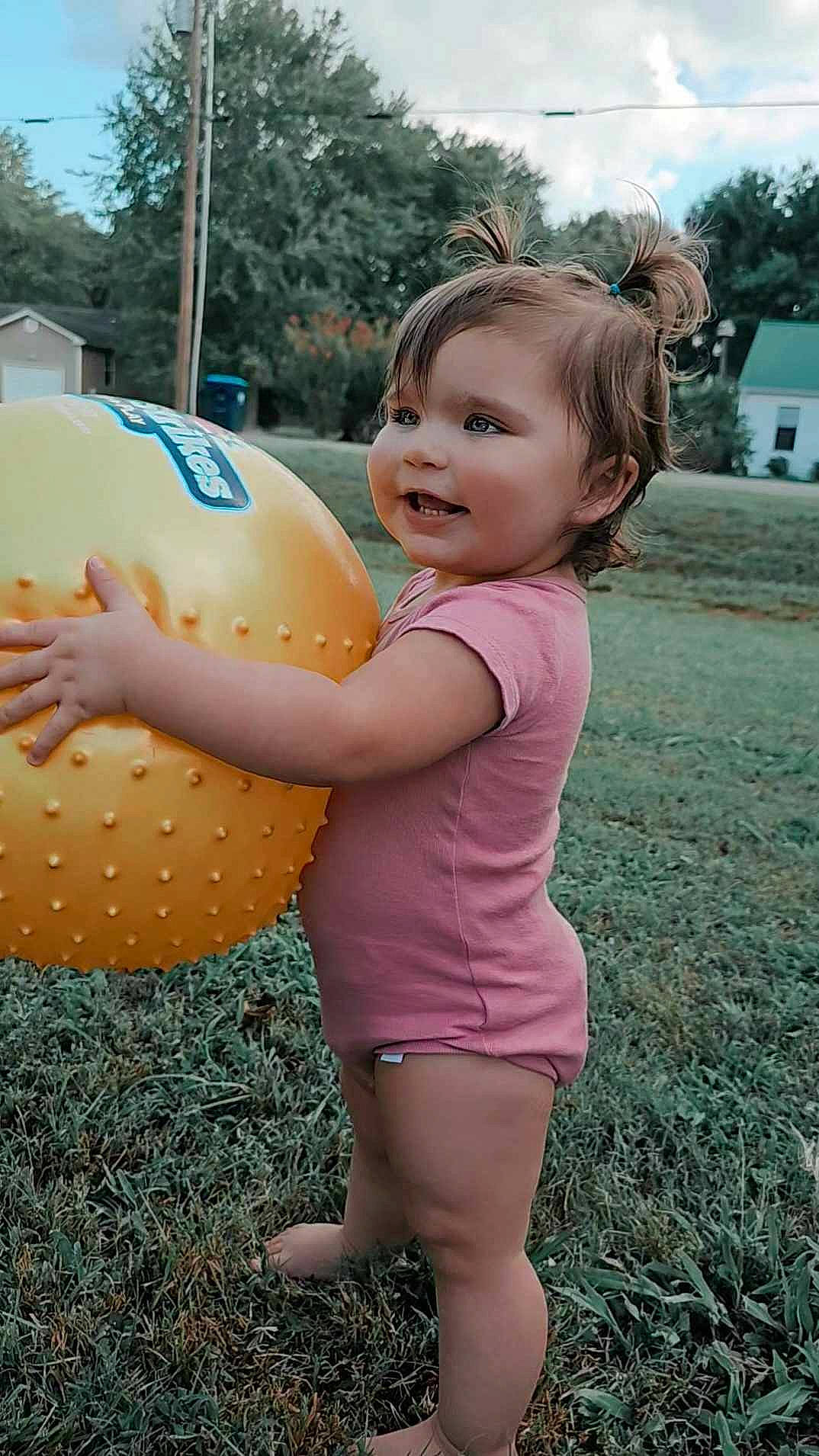 Iris joined the competition — help win amazing prizes! baby_toddler_clothing, child, facial_expression, finger, fun, gesture, grass, hand, happy, leisure, people_in_nature, person, pink, plant, recreation, sky, smile, standing, summer, toddler