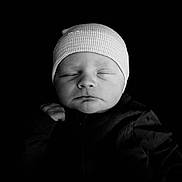 Booker is registered to the contest to win money with this photo: newborn, baby, sleeping, black_and_white, hat, knit_cap, infant, portrait, peaceful, closed_eyes, soft_lighting, dark_background, face, skin, cute, small_hand, cozy, monochrome, child, young