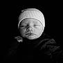 newborn, baby, sleeping, black_and_white, hat, knit_cap, infant, portrait, peaceful, closed_eyes, soft_lighting, dark_background, face, skin, cute, small_hand, cozy, monochrome, child, young