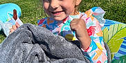 Aubrey joined the competition — help win amazing prizes! child, girl, smiling, towel, popsicle, grass, sunny_day, outdoor, inflatable_float, colorful_clothing, people, park, summer, happy, nature, playful, fun, relaxing, daylight, casual