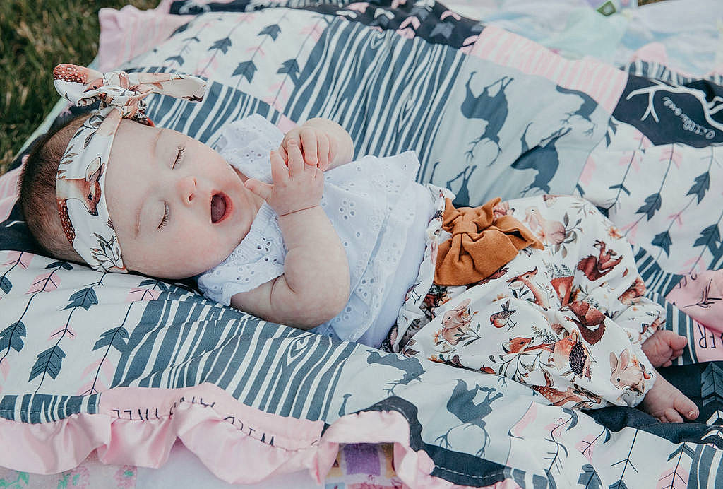 Brynlee joined the competition — help win amazing prizes! baby, baby_toddler_clothing, bedding, child, comfort, flesh, grass, happy, hat, headwear, leisure, linens, pattern, person, plaid, portrait_photography, sitting, sleeve, textile, toddler