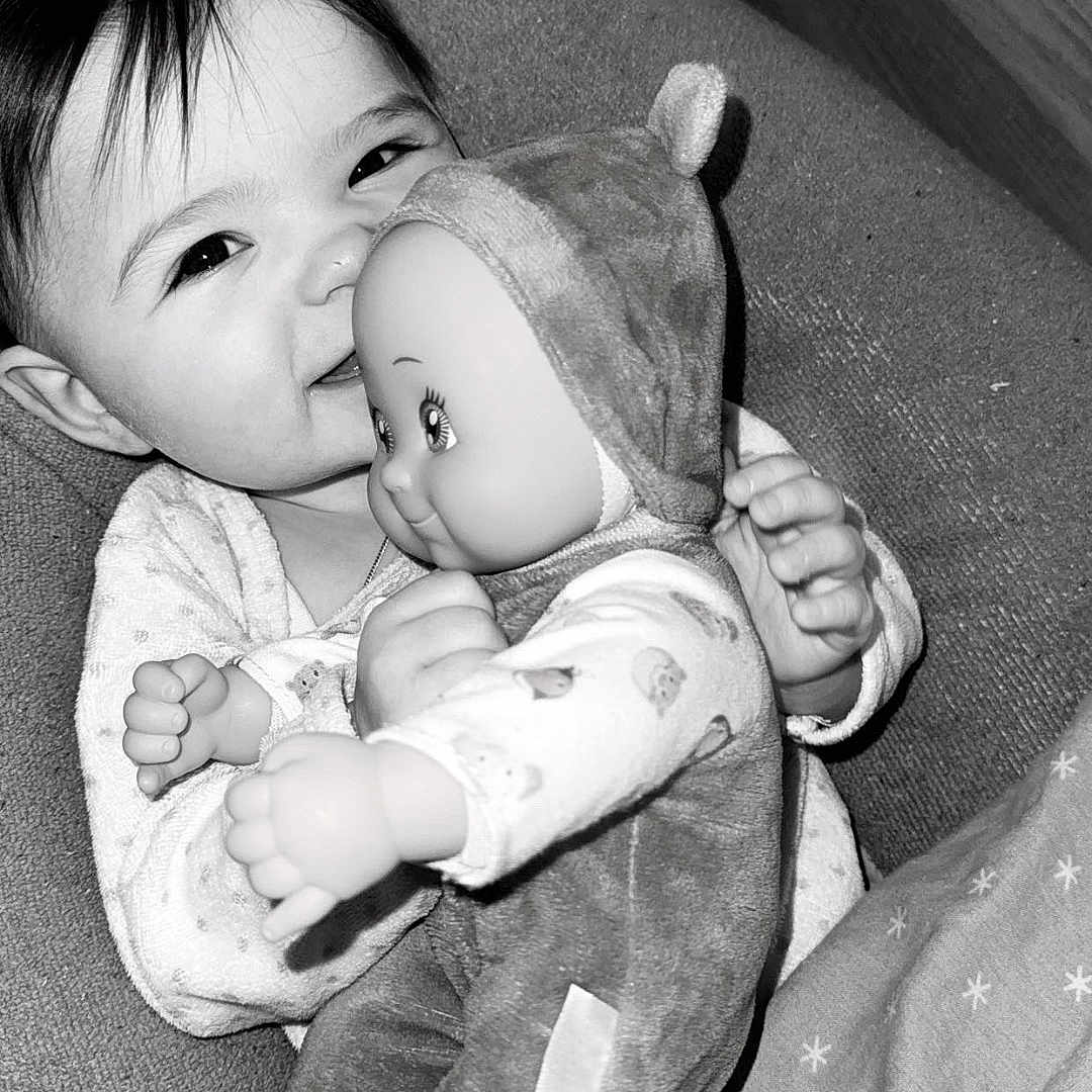 Lynaë a rejoint le concours — aidez-le/la à gagner de superbes lots ! baby, black_and_white, blanket, child, clothing, couch, cozy, cute, doll, face, furniture, hand, happy, hug, indoor, infant, portrait, smiling, soft, toy