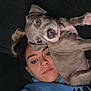Diesel is registered to the contest to win money with this photo: person, dog, puppy, face, lying_down, blue_clothing, nose_ring, pet, animal, casual, indoor, closeup, young_adult, black_background, cute, companion, resting, bond, expression, portrait