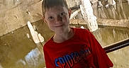 Hunter is registered to the contest to win money with this photo: boy, cave, cave_tour, child, exploring, indoor, photograph, portrait, railing, red_shirt, rock_formation, rocky_background, smiling, spiderman, stalactites, stalagmites, standing, superhero, tourist, underground
