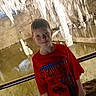 Hunter is registered to the contest to win money with this photo: child, boy, smiling, portrait, cave, stalactites, stalagmites, rock_formation, underground, exploring, tourist, red_shirt, spiderman, superhero, indoor, railing, rocky_background, cave_tour, standing, photograph