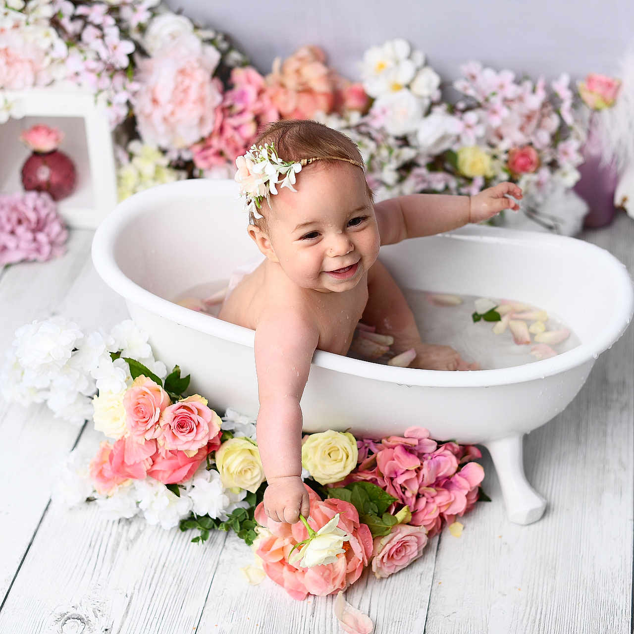 Lou a rejoint le concours — aidez-le/la à gagner de superbes lots ! baby, bathtub, water, flowers, flower_petals, headband, smiling, happy, infant, white_tub, pink_flowers, yellow_flowers, decor, wooden_floor, splashing, cute, portrait, indoor, child, flower_arrangement