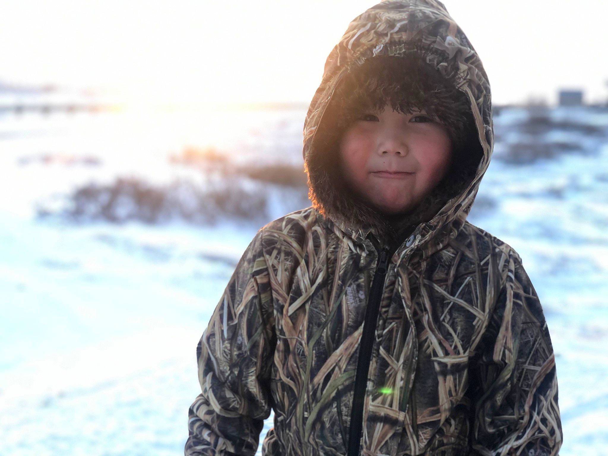 Gabriel is registered to the contest to win money with this photo: body_of_water, cap, eye, flash_photography, freezing, fun, fur, happy, ice_cap, jacket, knit_cap, landscape, outerwear, people_in_nature, person, rock, sand, sky, snow, toddler