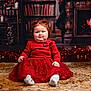 Amélia a rejoint le concours — aidez-le/la à gagner de superbes lots ! background, bow, carpet, child, christmas, curly_hair, cute, decorations, face, festive, fireplace, floor, holiday, indoors, lights, portrait, red_dress, smile, socks, toddler