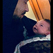 Micah is registered to the contest to win money with this photo: affection, baby, beard, blanket, bonding, caring, child, closeup, face, family, holding, hoodie, indoor, love, man, person, portrait, smile, warm, wood_paneling