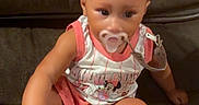 Sariyah joined the competition — help win amazing prizes! adorable, baby, child, clothing, comfort, couch, cute, face, hair, hand, indoor, infant, legs, pacifier, person, pink_bows, relaxed, sitting, socks, young_child