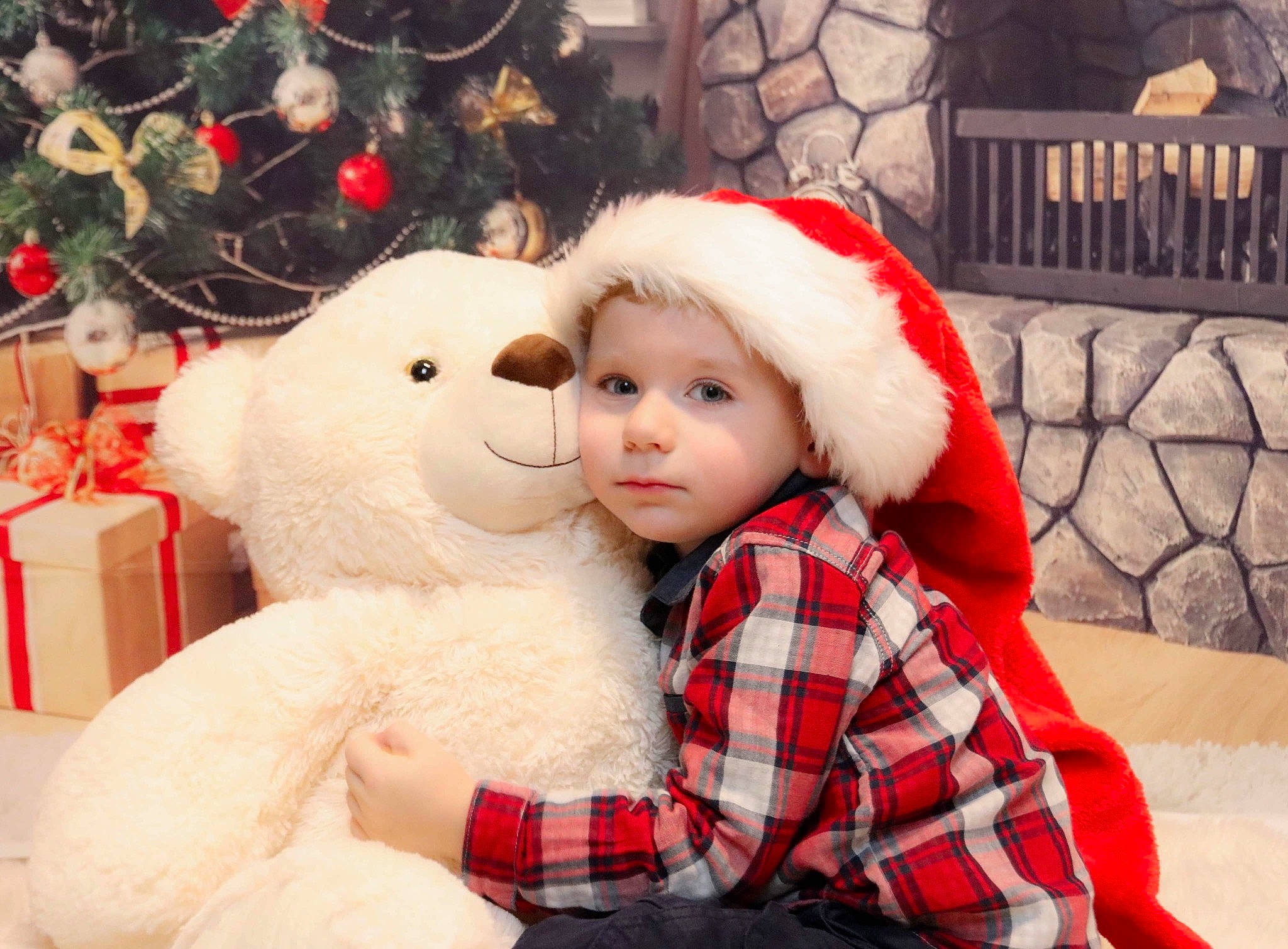 Noé participe au concours pour gagner de l'argent avec cette photo : christmas_eve, christmas_tree, event, fun, fur, fur_clothing, happy, hat, head, headwear, holiday, human_body, person, plaid, red, sleeve, tartan, textile, toddler, toy