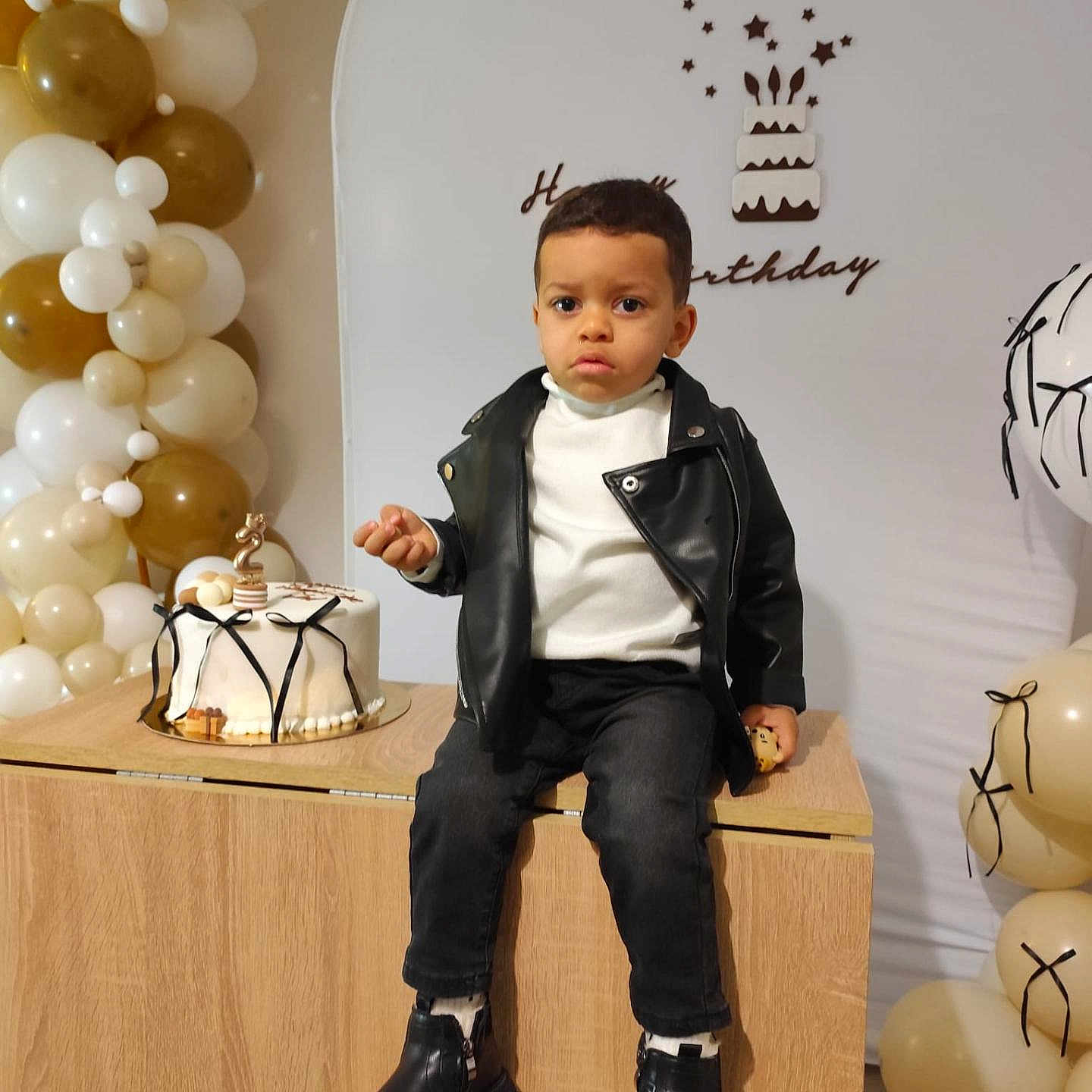 Jad participe au concours pour gagner de l'argent avec cette photo : balloons, birthday, boots, boy, cake, casual_clothing, celebration, child, decorations, festive, gold, happy, indoor, leather_jacket, number_two_candle, party, portrait, smile, table, white