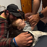 Lucas joined the competition — help win amazing prizes! baby, child, man, dog, cap, glasses, hands, laughing, indoor, bed, plaid_shirt, watch, bracelet, gray_shirt, black_shorts, playing, happy, family, pet, candid