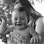 Lucas is registered to the contest to win money with this photo: baby, child, smiling, happy, person, adult, holding, arm, face, hair, outdoor, nature, leaf, black_and_white, portrait, closeup, clothing, skin, expression, joy