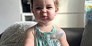 Mia joined the competition — help win amazing prizes! toddler, child, water_bottle, sitting, indoor, couch, blanket, expression, cute, face, clothing, person, furniture, home, soft_light, casual, bottle, young_child, baby, portrait