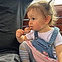 Mia is registered to the contest to win money with this photo: toddler, child, lollipop, sprinkles, denim_overalls, striped_leggings, pink_skirt, person, sitting, hair_ponytail, side_profile, bench, casual_clothing, cute, snack, indoor, closeup, happy, holding, playful