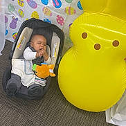 Davontae joined the competition — help win amazing prizes! baby, bunny, car_seat, carpet, celebration, child, colorful, cute, decorations, easter, floor, holiday, indoor, infant, inflatable, pattern, playful, smiling, toy, yellow