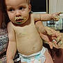 baby, toddler, child, diaper, messy, cake, food, crumbs, face, hand, arm, skin, person, indoor, kitchen, adult_hand, curious, smudged, closeup, sitting