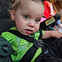 Dylan is registered to the contest to win money with this photo: toddler, child, car_seat, seatbelt, green_shirt, black_pants, indoor, curious, wide_eyes, close_up, baby, person, straps, sitting, young_child, casual_clothing, unfocused, candid, portrait, infant