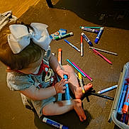 Nova joined the competition — help win amazing prizes! toddler, child, white_bow, markers, floor, sitting, playing, colorful, toy, clothing, short_sleeves, barefoot, hair, indoor, person, art_supplies, container, light_and_shadow, curious, young_child