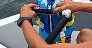 Buck joined the competition — help win amazing prizes! adult, baby, boat, child, daytime, grip, hands, life_jacket, life_safety, nautical, outdoor, person, recreation, safety, sitting, summer, water, water_sports, water_surface, yawning