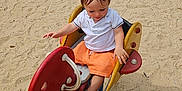 Maylonn a rejoint le concours — aidez-le/la à gagner de superbes lots ! casual_clothing, child, daylight, elephant, fun, happy, outdoor, park, play, playground, recreation, rocking_toy, sand, sandals, shorts, smiling, summer, toddler, toy, wood