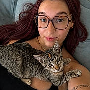 Belly participe au concours pour gagner de l'argent avec cette photo : woman, cat, glasses, purple_hair, tabby_cat, couch, tattoo, selfie, indoor, relaxed, pet, laying_down, black_top, closeup, face, feline, human, portrait, casual, cozy