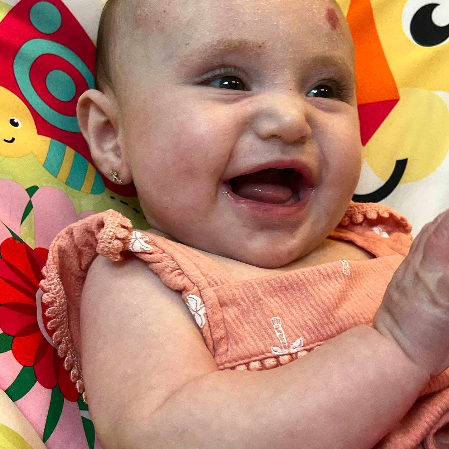 Blakelynn joined the competition — help win amazing prizes! arm, baby, cheerful, child, closeup, colorful_background, cute, earrings, face, flower_pattern, happy, indoors, infant, laughing, peach_clothing, playful, portrait, skin, smiling, young_child