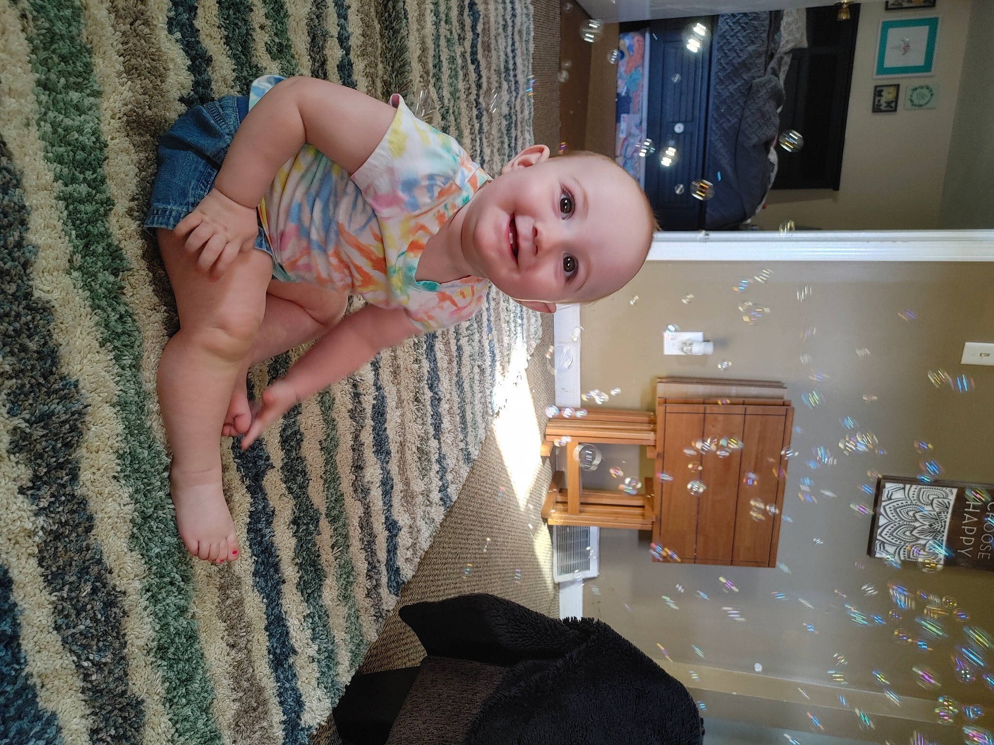 Kennedy is registered to the contest to win money with this photo: baby, baby_toddler_clothing, box, child, comfort, floor, flooring, foot, fun, happy, human_leg, joy, knee, pattern, person, room, shipping_box, sitting, smile, thigh