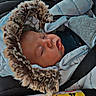 airbag_label, baby, car_interior, car_seat, child, child_safety, close_up, cozy, cute, fur_hood, infant, jacket, nap, peaceful, portrait, seatbelt, sleeping, transportation, warm_clothing, winter_wear