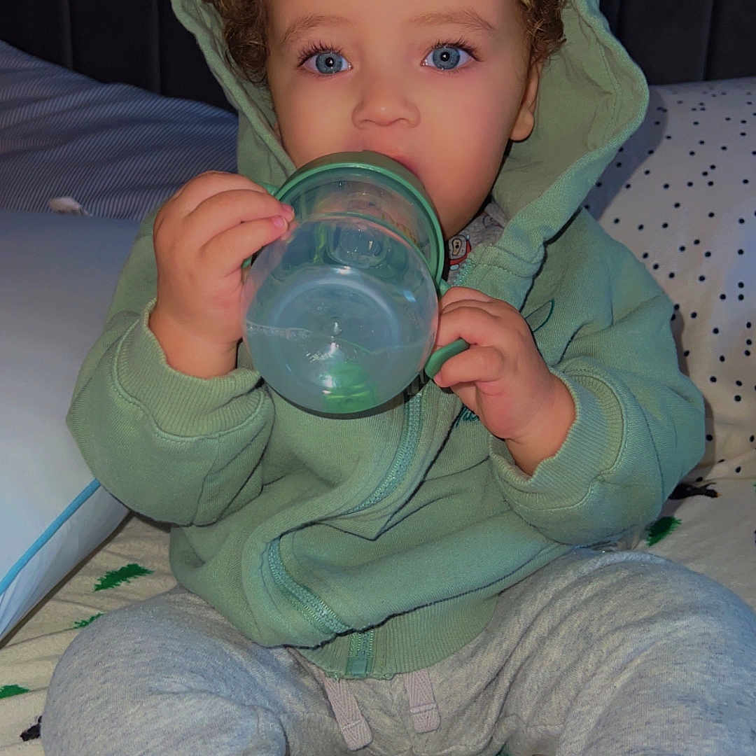 Omarii is registered to the contest to win money with this photo: baby, bodypart, bonnet, clothing, cup, face, finger, hand, hat, head, hood, hoodie, jeans, knitwear, pants, person, photography, portrait, sweater, sweatshirt