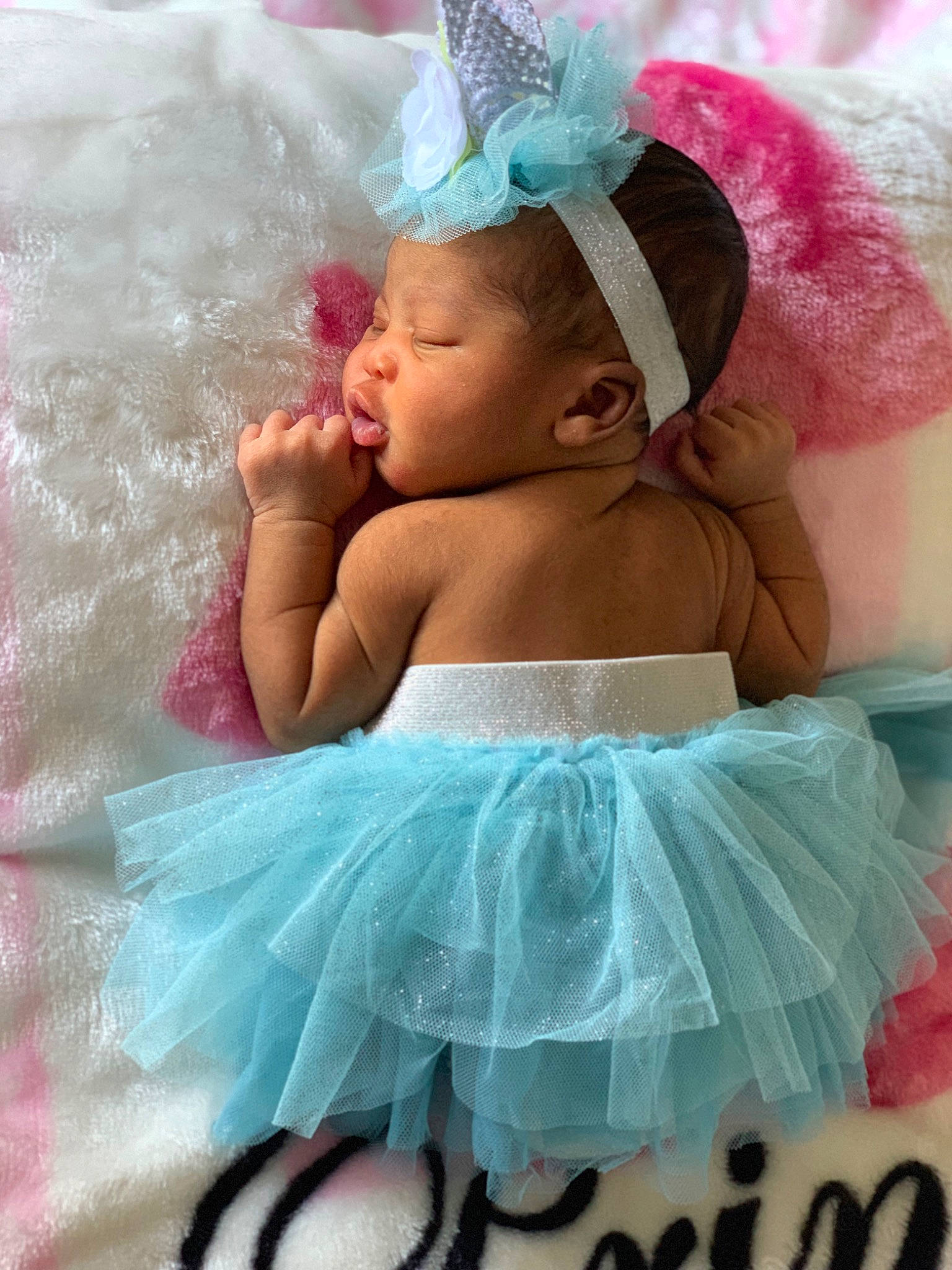 Malia is registered to the contest to win money with this photo: abdomen, aqua, azure, baby, baby_products, baby_toddler_clothing, blue, child, fashion_accessory, happy, headband, headpiece, linens, magenta, person, pink, ruffle, textile, thigh, toddler