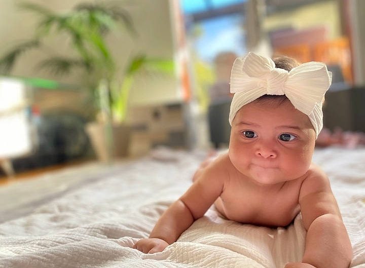 Mya a rejoint le concours — aidez-le/la à gagner de superbes lots ! baby, cap, cheek, child, comfort, fashion_accessory, flooring, flowerpot, fun, hair_accessory, happy, headpiece, headwear, houseplant, person, plant, room, skin, smile, thumb