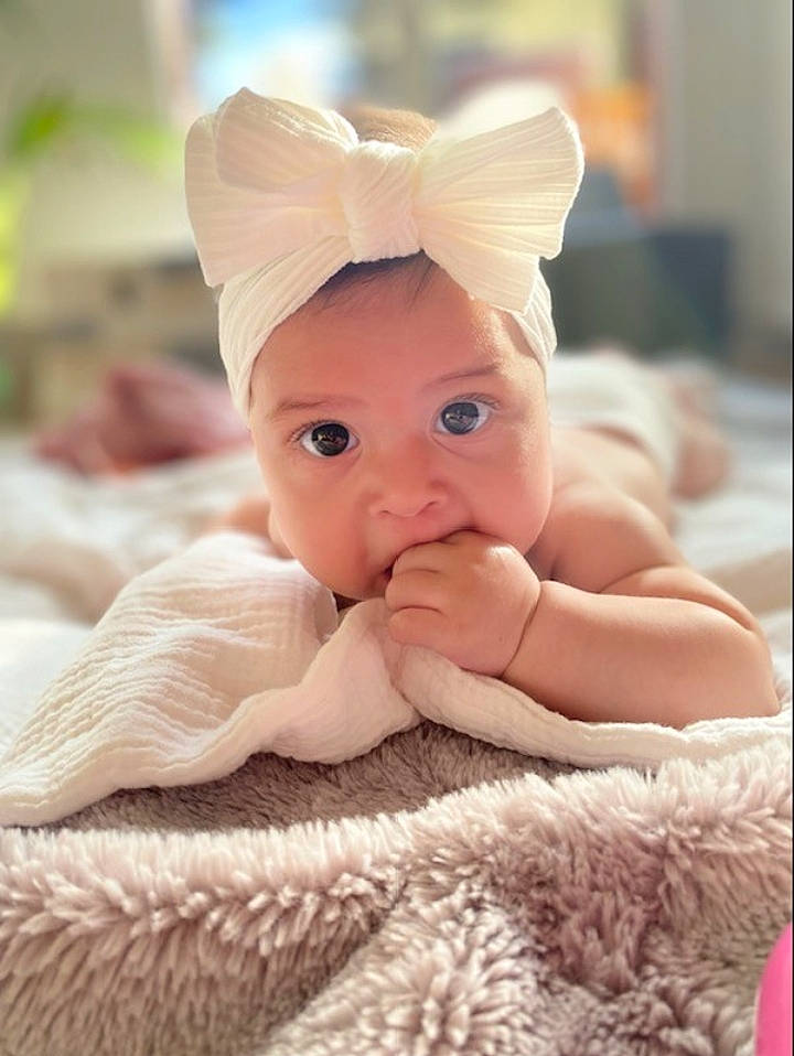 Mya a rejoint le concours — aidez-le/la à gagner de superbes lots ! baby, baby_toddler_clothing, cap, cheek, chin, comfort, eyebrow, face, hand, happy, head, headgear, headpiece, iris, linens, lip, nail, peach, person, surprise