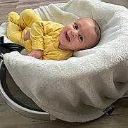 Mateo joined the competition — help win amazing prizes! baby, smiling, yellow_outfit, blanket, baby_rocker, wooden_floor, happy, infant, cozy, indoor, child, cute, face, person, clothing, resting, soft, comfort, portrait, young
