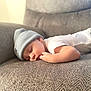 Mateo is registered to the contest to win money with this photo: apparel, baby, beanie, child, couch, cozy, cute, face, furniture, gray, hat, indoors, infant, peaceful, portrait, relaxation, resting, sleeping, soft_light, warm