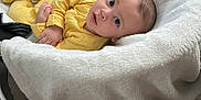 Mateo is registered to the contest to win money with this photo: baby, baby_seat, blanket, casual, child, comfortable, cozy, curious, cute, floor, home, indoor, infant, looking_up, newborn, portrait, resting, soft_texture, wooden_floor, yellow_clothing