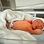 newborn, baby, sleeping, blanket, hospital_bed, infant, hat, peaceful, soft, skin, lying_down, cute, child, bed, resting, healthcare, toddler, nursery, comfort, indoors
