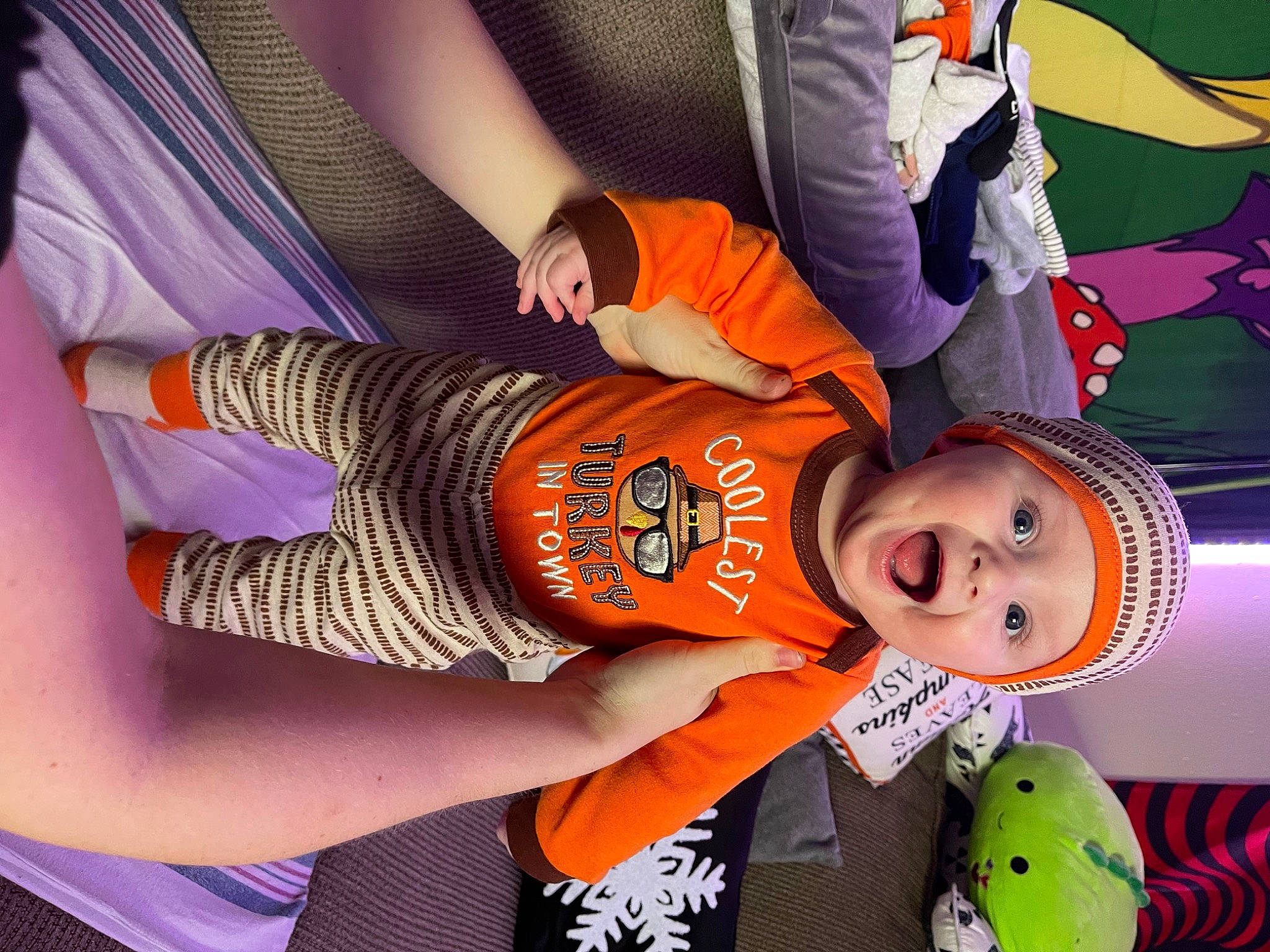 Bennett is registered to the contest to win money with this photo: child, cool, fun, happy, hat, headwear, human_leg, knee, leisure, mouth, nail, orange, pattern, person, purple, recreation, surprise, thigh, thumb, toddler