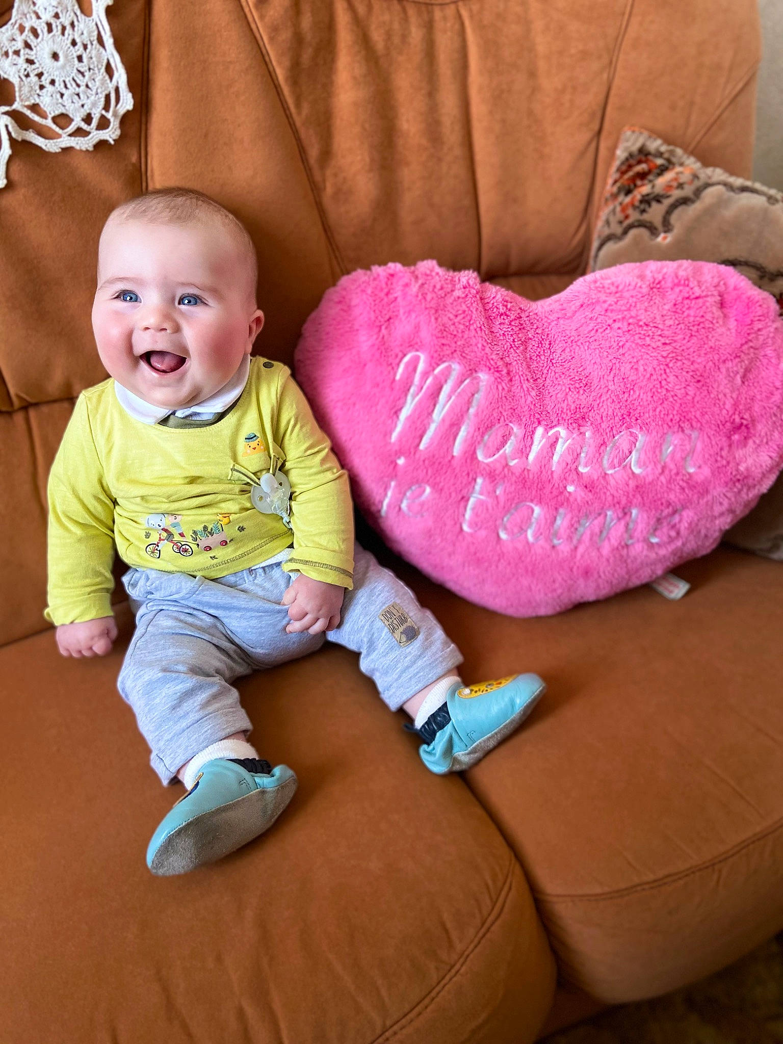 Livio participe au concours pour gagner de l'argent avec cette photo : arm, baby_toddler_clothing, cheek, child, comfort, finger, flooring, happy, head, human_body, lap, leg, mouth, organ, person, pink, skin, sleeve, smile, textile