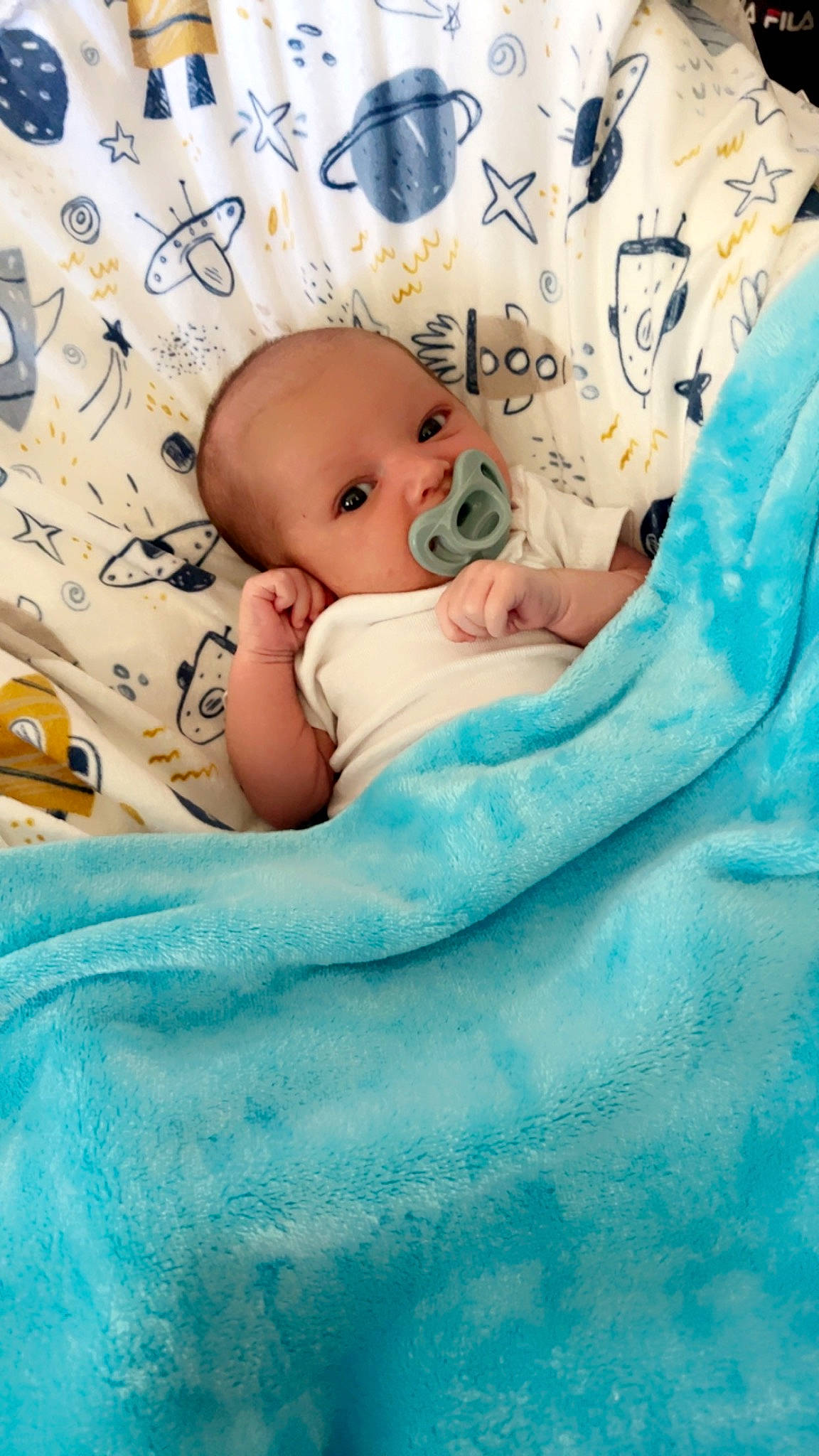 Matthew is registered to the contest to win money with this photo: aqua, baby, baby_products, baby_sleeping, baby_toddler_clothing, bedding, bedtime, blue, cheek, child, comfort, face, linens, pattern, person, room, sitting, skin, sleeve, textile