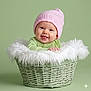 Grace joined the competition — help win amazing prizes! baby, infant, smiling, pink_hat, green_clothing, basket, fluffy_blanket, cute, portrait, studio, child, happy, tongue_out, knit_hat, soft_light, green_background, cozy, newborn, baby_boy, warm
