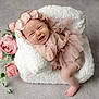 baby, infant, pink, flower_headband, cushion, smile, happy, soft_texture, flowers, portrait, cute, toddler, indoor, child, newborn, fabric, relaxed, skin, head, pose