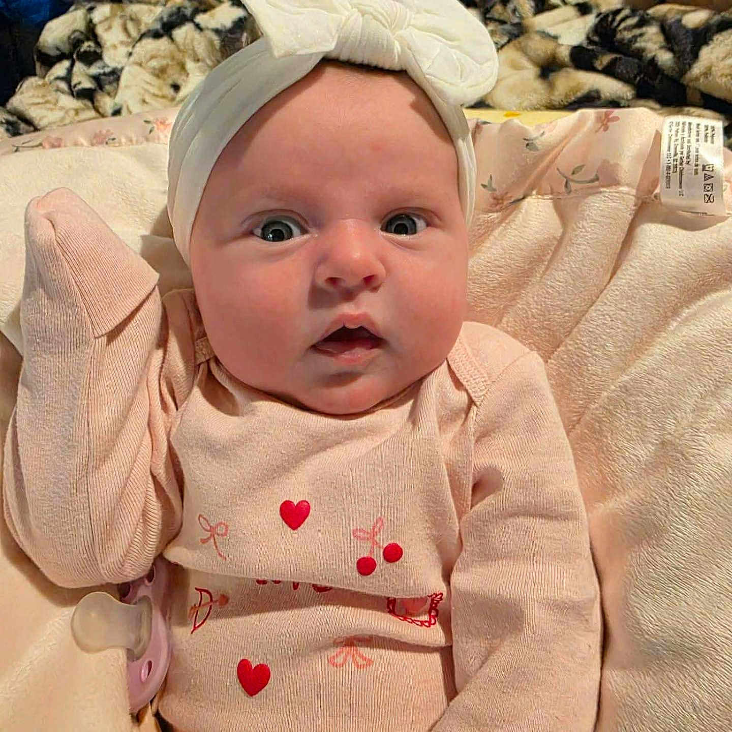 Lavinia joined the competition — help win amazing prizes! baby, blanket, bow, cherries, child, clothing, cozy, cute, expression, headband, hearts, indoors, infant, lying_down, pacifier, pink_clothing, plush, portrait, soft_texture, wide_eyes