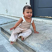 Alison joined the competition — help win amazing prizes! toddler, child, smiling, sitting, outdoor, concrete, step, door, hair_accessory, pony_tail, beige_clothing, sandals, cute, happy, person, sidewalk, curb, wall, exploring, young_child